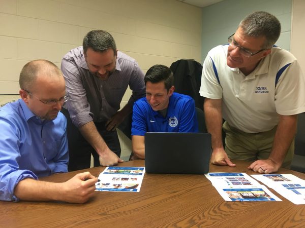 Clay Showalter, Mike Stoltzfus, Andrew Gascho and Dave Bechler review plans for the athletics section of the website, one of the most visited parts of the school's site.