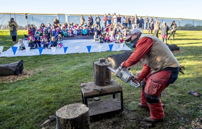 Local chainsaw artist Sean Haifee carves a jack-o-lantern out of a log during the demonstration for students at EMES. Photo by Daniel Lin/DN-R