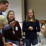 A representative of Rockingham Rotary encourages We Serve co-chair Miriam Rhodes '22 to consider a Rotary opportunity. Onlookers include club sponsor Wendy Stapleton and former We Serve president Abby Stapleton '19.