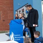 Paul Leaman, head of school, holds the  microphone for fifth grader Marlowe Nichols as she shares reflections.