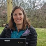 Gini Trotter, middle school counselor and elementary peacebuilding teacher, enjoying the blossoms while she works