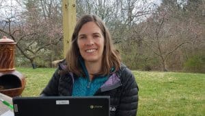 Gini Trotter, middle school counselor and elementary peacebuilding teacher, enjoying the blossoms while she works