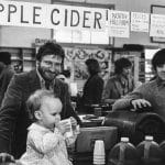 Keith and Eric Helmuth at their Farm Market stall with a young customer, 1982