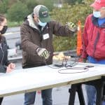 Malea Gascho (art teacher), Justin King (high school principal) and Kevin King (Justin's dad) at the solar barn raising