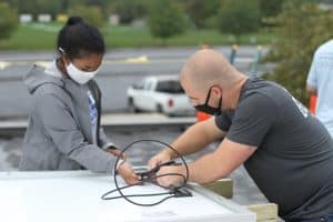 Rahel Lema '21, and Everett Brubaker '13 at the solar barn raising