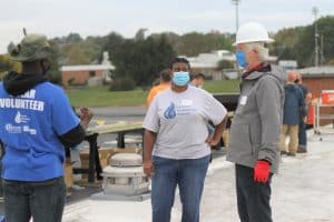 Debbie Katz, high school counselor, with Tony Smith of Secure Futures, talking with Nikita Stoll at the solar barn raising