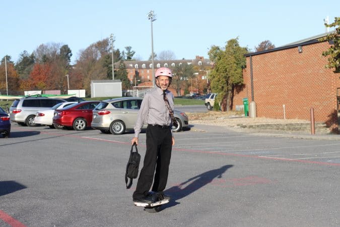 Curt Stutzman arrives for a day at work on his OneWheel, tie flying...