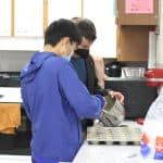 Student bakers preparing items for golfer goodie bags