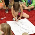 Kindergarten students take turns signing the peace pledge, 2021