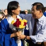 Father congratulates son at graduation with flowers