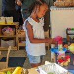 A new kindergarten student checks out the classroom while parents visit at Back to School night.