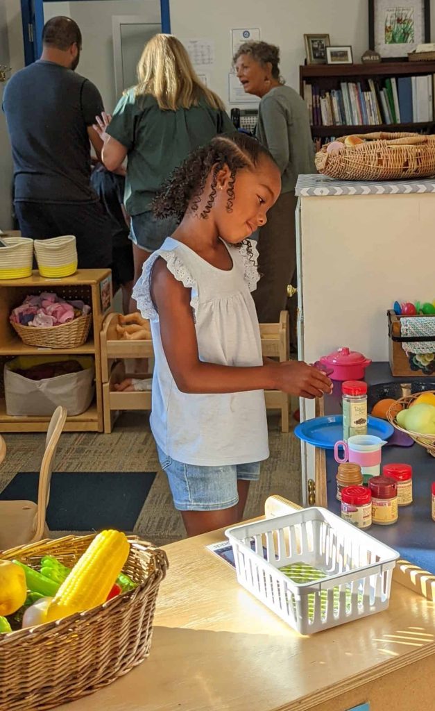 A new kindergarten student checks out the classroom while parents visit at Back to School night.