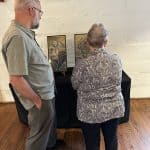 The Kniss family admires local art being auctioned at the event. 