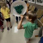 A Kinder student holds up his handmade heart during the peace parade