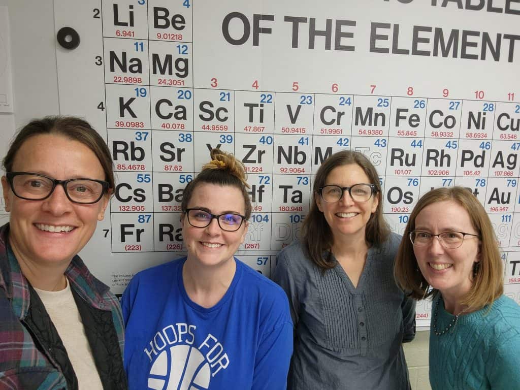 Science Teachers in front of the periodic table of elements.